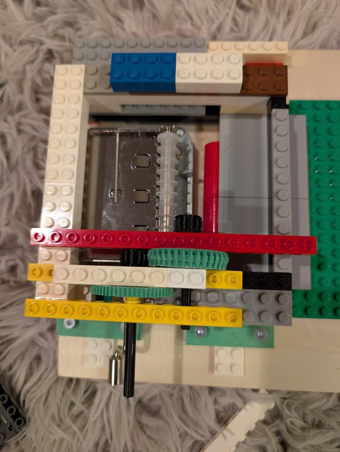 An early portion of the music box, just showing Lego gears connecting to the music box gear train via a 3D printed gear